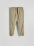 Spodnie typu jogger o dopasowanym fasonie, wykonane z bawełnianej tkaniny. - beżowy
