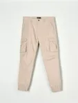 Spodnie jogger z kieszeniami cargo, uszyty z bawełny z dodatkiem elastycznych włókien. - kremowy