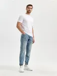 Spodnie jeansowe o kroju jogger uszyte z bawełnianej tkanin z dodatkiem elastycznych włókien. - niebieski