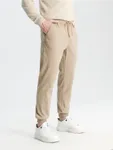 Spodnie o kroju jogger fit uszyte z baweły z domieszką elastycznych włókien. - beżowy