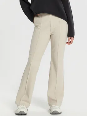 Eleganckie spodnie o kroju flare uszyte z elastycznego, podkreślającego sylwetkę materiału. - kremowy