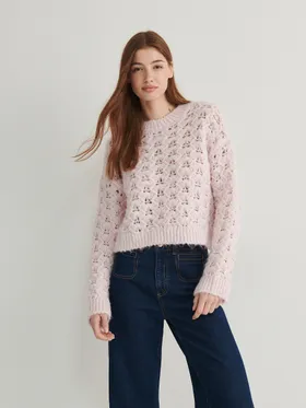 Sweter o swobodnym fasonie, wykonany z ażurowej dzianiny. - pastelowy róż