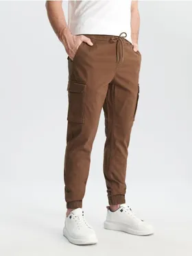 Wygodne spodnie jogger cargo wykonane z bawełnianej tkaniny z dodatkiem elastycznych włókien. - brązowy