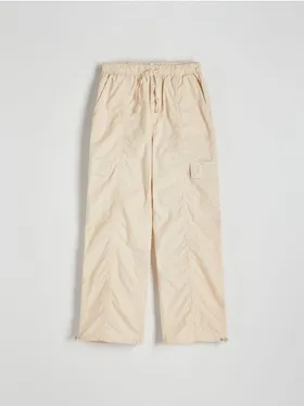 Spodnie typu jogger, wykonane z bawełnianej tkaniny. - kremowy