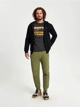 Bawełniane spodnie dresowe o kroju regular jogger z ozdobnymi przeszyciami. - zielony