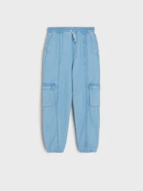 Wygodne spodnie jeansowe o kroju jogger, wykonane z bawełnianej tkaniny. - niebieski