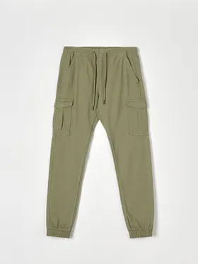 Spodnie jogger z kieszeniami cargo uszyte z bawełny z domieszką elastycznych włókien. - zielony