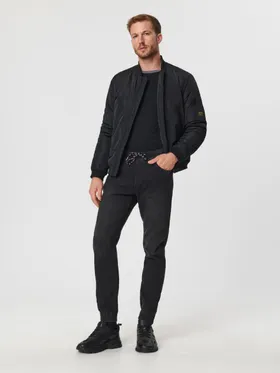 Spodnie jeansowe o kroju jogger uszyte z bawełnianej tkaniny z dodatkim szybkoschnącego materiału oraz elastycznych włókien. - czarny