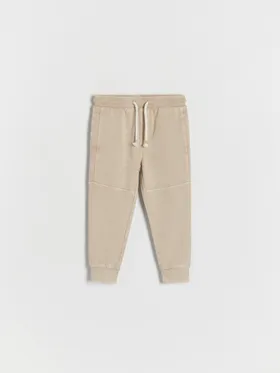 Dresowe spodnie typu jogger, wykonane z gładkiej, bawełnianej dzianiny. - beżowy