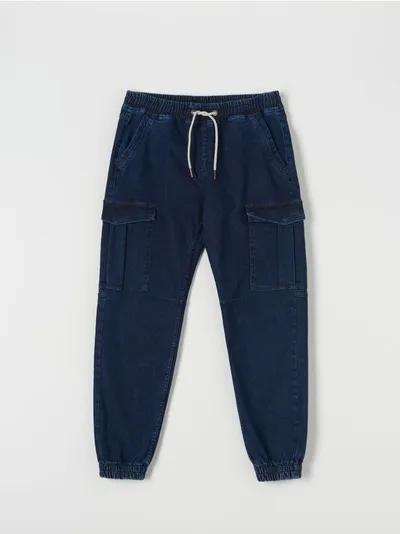 Sinsay Spodnie jeansowe o kroju jogger z kieszeniami cargo. Uszyte z bawełny z domieszką elastycznych włókien. - niebieski