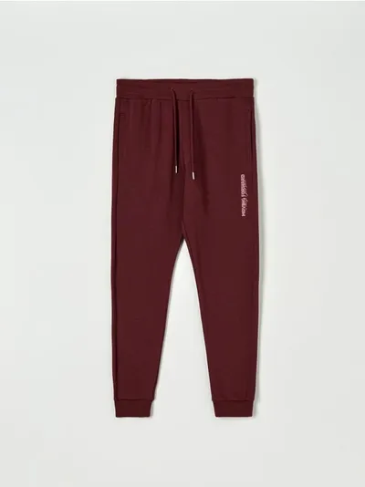 Sinsay Bawełniane spodnie o kroju jogger z nadrukiem na nogawce. - czerwony
