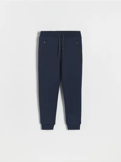 Reserved Dresowe spodnie typu jogger, wykonane z przyjemnej w dotyku dzianiny z bawełną. - granatowy