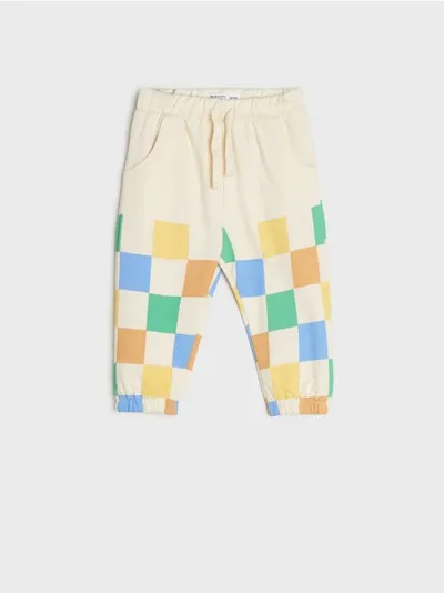 Sinsay Bawełniane spodnie dresowe o kroju jogger ozdobione kolorową szachownicą. - kremowy