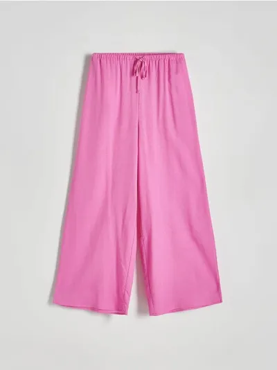 Reserved Spodnie o swobodnym fasonie, uszyte z tkaniny z dodatkiem bawełny oraz wiskozy. - różowy