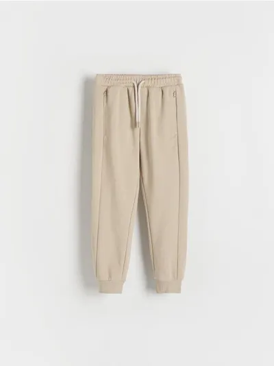 Reserved Spodnie typu jogger, wykonane z przyjemnej w dotyku, bawełnianej dzianiny. - beżowy