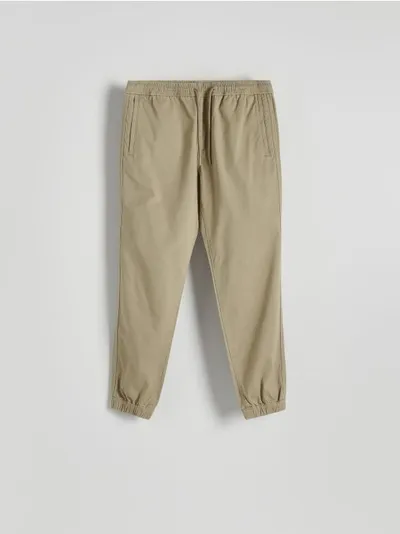 Reserved Spodnie typu jogger o dopasowanym fasonie, wykonane z bawełnianej tkaniny. - beżowy