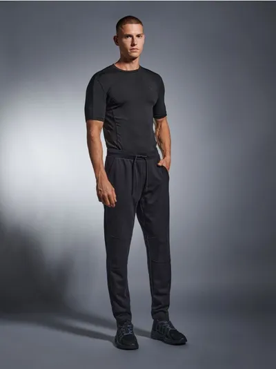 Spodnie o kroju jogger z kolekcji SNSY PERFORMANCE. Uszyte z szybkoschnącego materiału z dodatkiem bawełny. Możesz dobrać do nich pasującą bluzę i stworzyć komplet. - czarny