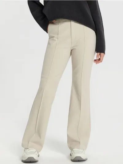 Sinsay Eleganckie spodnie o kroju flare uszyte z elastycznego, podkreślającego sylwetkę materiału. - kremowy