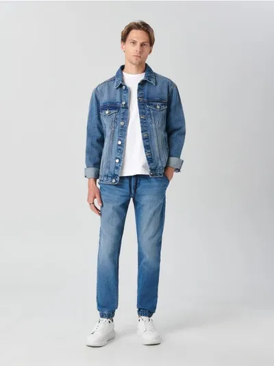 Sinsay Spodnie jeansowe o kroju jogger, wykonane z tkaniny z dodatkiem elastycznych włókien. - granatowy