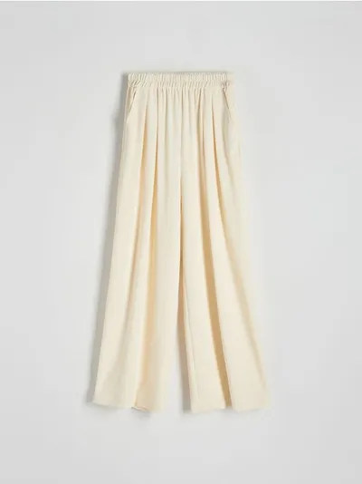 Reserved Spodnie o swobodnym fasonie, wykonane z gładkiej i przyjemnej w dotyku tkaniny. - złamana biel