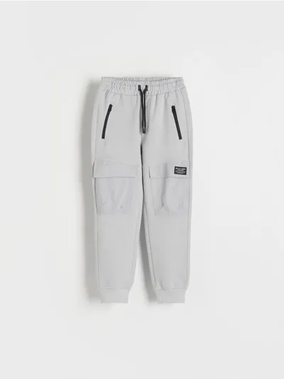 Reserved Dresowe spodnie typu jogger, wykonane z gładkiej, bawełnianej dzianiny. - jasnoszary