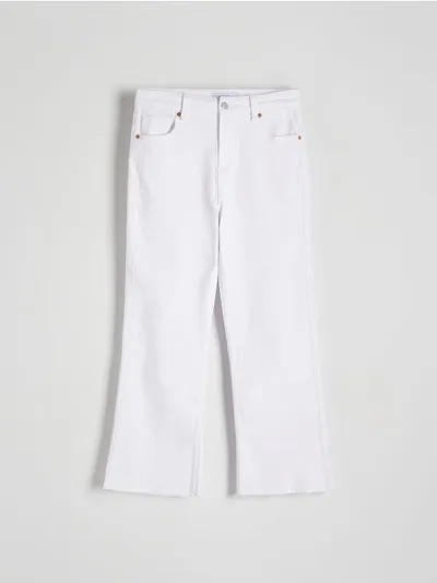Reserved Jeansy o dopasowanym fasonie z rozszerzanymi nogawkami, uszyte z bawełny z dodatkiem elastycznych włókien. - biały