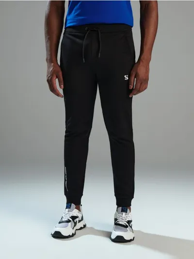 Sinsay Spodnie o kroju jogger z kolekcji SNSY PERFORMANCE. Uszyte z szybkoschnącego materiału z dodatkiem bawełny. Możesz dobrać do nich pasującą bluzę i stworzyć komplet. - czarny
