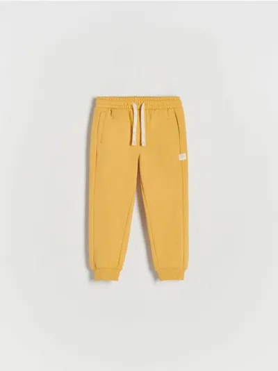 Reserved Spodnie typu jogger, wykonane z przyjemnej w dotyku, bawełnianej dzianiny. - kremowy