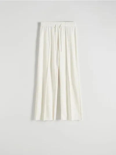 Reserved Spodnie o swobodnym fasonie, wykonane z gładkiej dzianiny z bawełną. - złamana biel