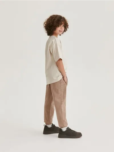 Reserved Dresowe spodnie typu jogger, wykonane z przyjemnej w dotyku, bawełnianej dzianiny. - beżowy