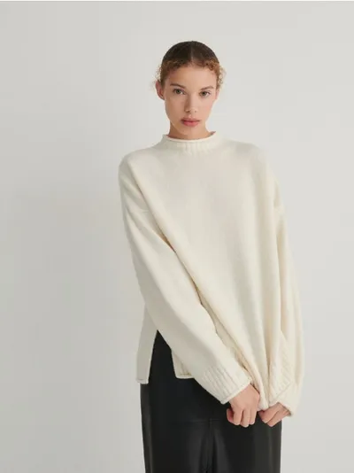 Reserved Sweter o obszernym kroju, wykonany z przyjemnej w dotyku dzianiny. - złamana biel