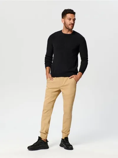 Sinsay Spodnie jeansowe o kroju jogger, uszyte z bawełny z domieszką szybkoschnącego materiału oraz elastycznych włókien. - beżowy
