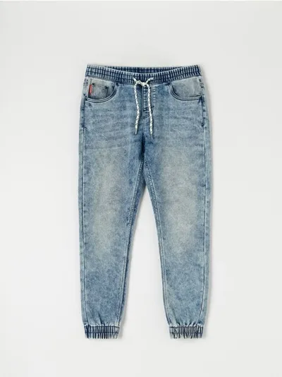 Sinsay Spodnie jeansowe o kroju jogger uszyte z bawełnianej tkaniny z dodatkim szybkoschnącego materiału oraz elastycznych włókien. - niebieski