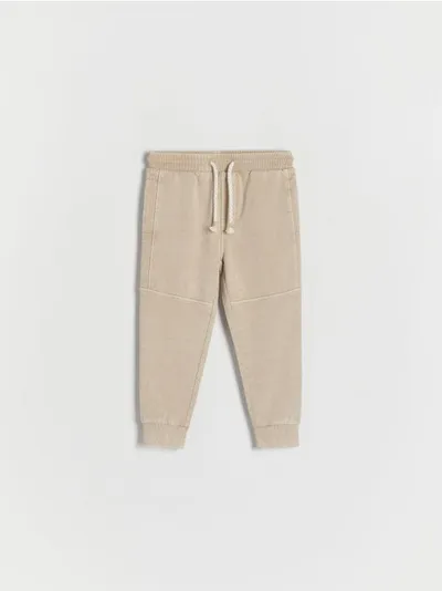 Reserved Dresowe spodnie typu jogger, wykonane z gładkiej, bawełnianej dzianiny. - beżowy
