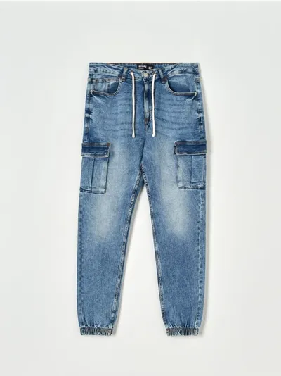 Sinsay Spodnie jeansowe o kroju jogger z kieszeniami cargo. Uszyte z bawełny z domieszką elastycznych włókien. - niebieski