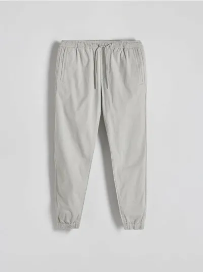 Reserved Spodnie typu jogger o dopasowanym fasonie, wykonane z bawełnianej tkaniny. - jasnoszary