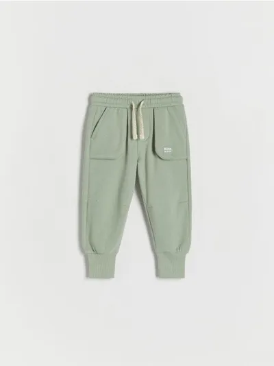 Reserved Dresowe spodnie typu jogger, wykonane z gładkiej, bawełnianej dzianiny. - jasnozielony