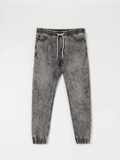 Sinsay Spodnie jeansowe o kroju jogger uszyte z bawełnianej tkaniny z dodatkim szybkoschnącego materiału oraz elastycznych włókien. - szary