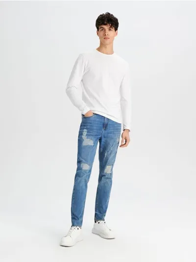 Sinsay Spodnie jeansowe z ozdobnymi przetarciami na nogawkach uszyte z bawełny z dodatkiem elastycznych włókien. - niebieski