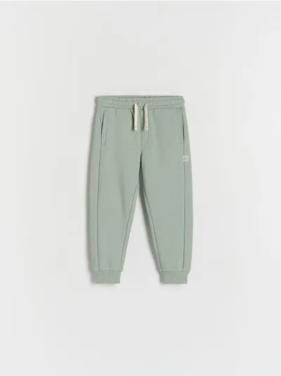 Reserved Spodnie typu jogger, wykonane z przyjemnej w dotyku, bawełnianej dzianiny. - jasnozielony
