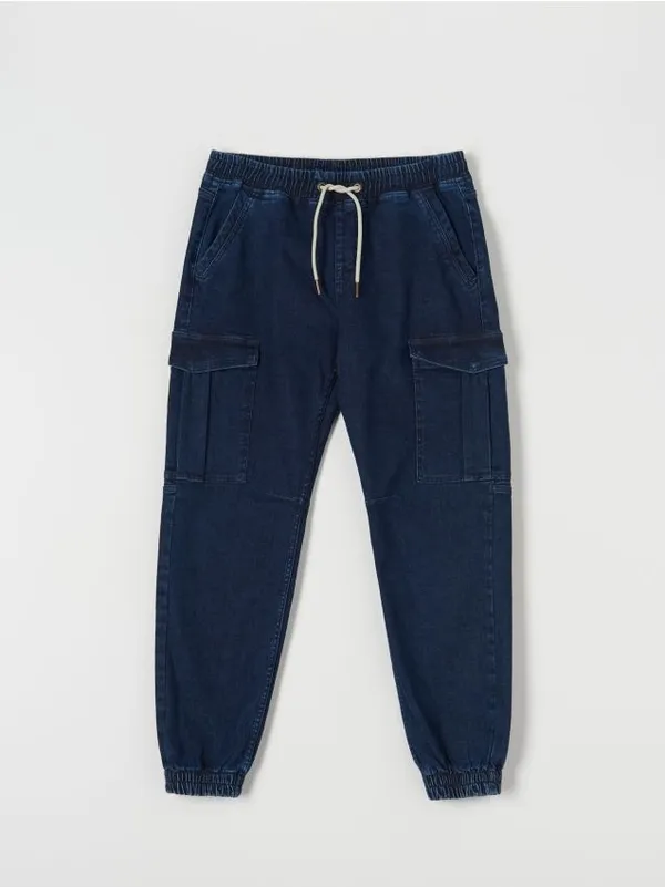 Spodnie jeansowe o kroju jogger z kieszeniami cargo. Uszyte z bawełny z domieszką elastycznych włókien. - niebieski