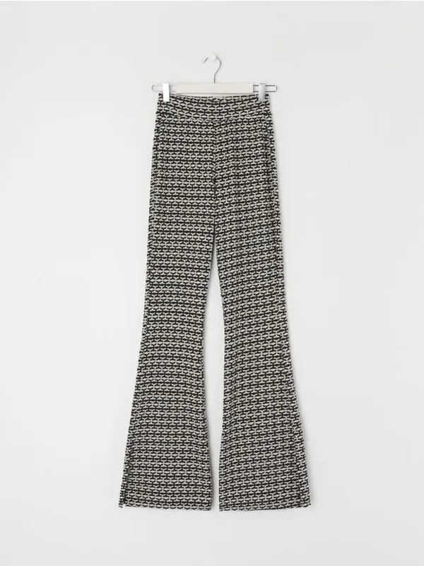 Wzorzyste spodnie o kroju flare wykonane z materiału zawierającego naturalne włókna. - wielobarwny