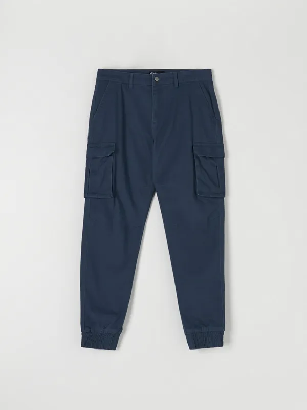 Spodnie jogger z kieszeniami cargo, uszyty z bawełny z dodatkiem elastycznych włókien. - niebieski