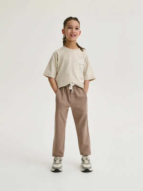 Spodnie typy jogger, wykonane z bawełnianej dzianiny dresowej. - brązowy