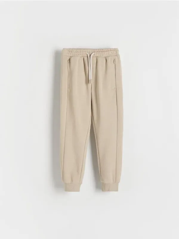 Spodnie typu jogger, wykonane z przyjemnej w dotyku, bawełnianej dzianiny. - beżowy
