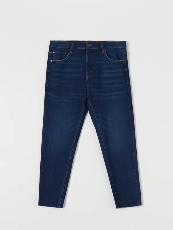 Spodnie jeansowe z surowym wykończeniem nogawek, uszyte z bawełny z domieszką elastycznych włókien. - granatowy