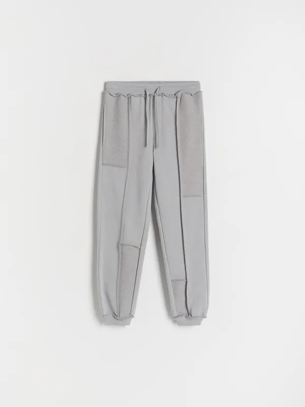 Spodnie typu jogger, wykonane z dresowej dzianiny z bawełną. - jasnoszary