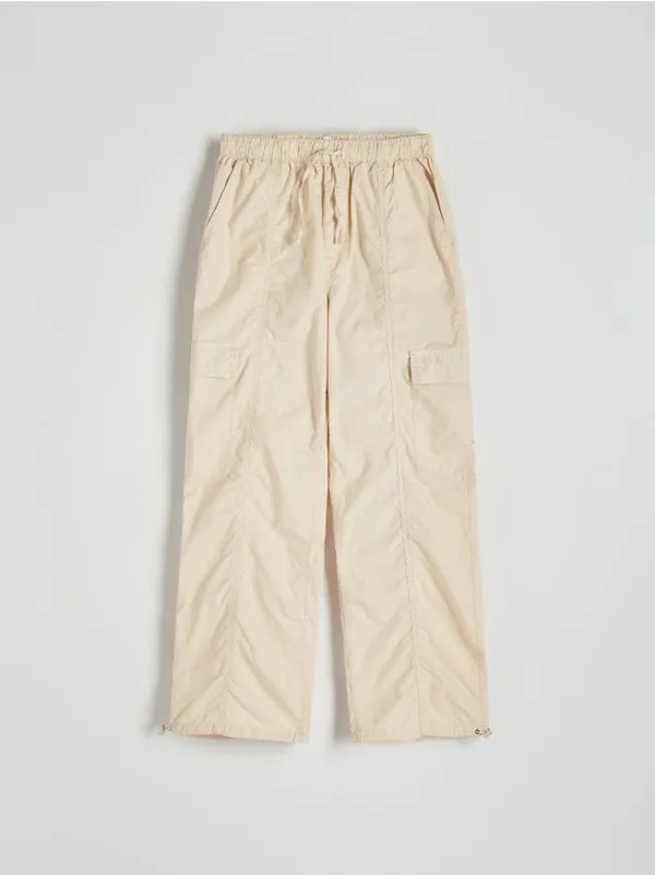 Spodnie typu jogger, wykonane z bawełnianej tkaniny. - kremowy