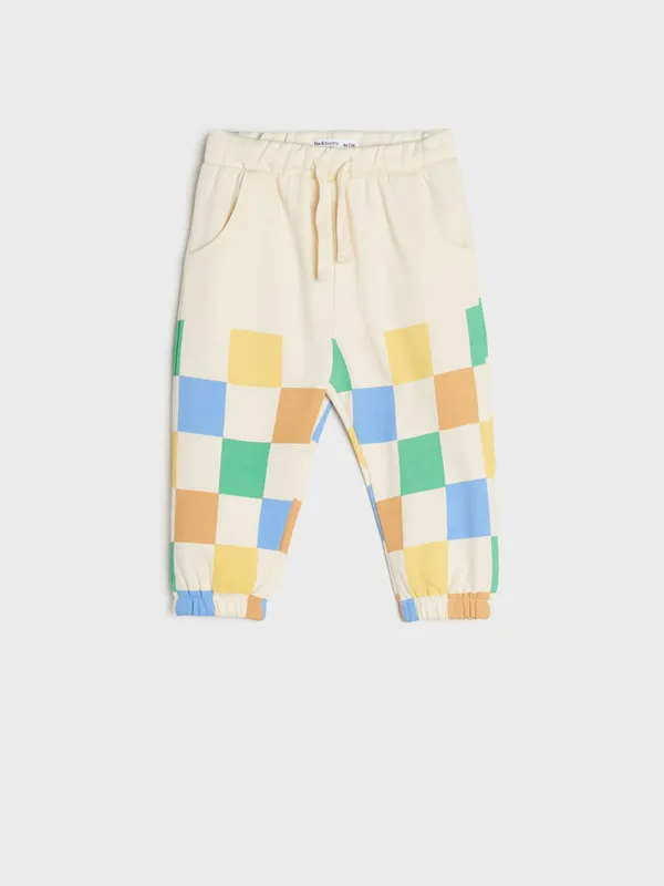 Bawełniane spodnie dresowe o kroju jogger ozdobione kolorową szachownicą. - kremowy