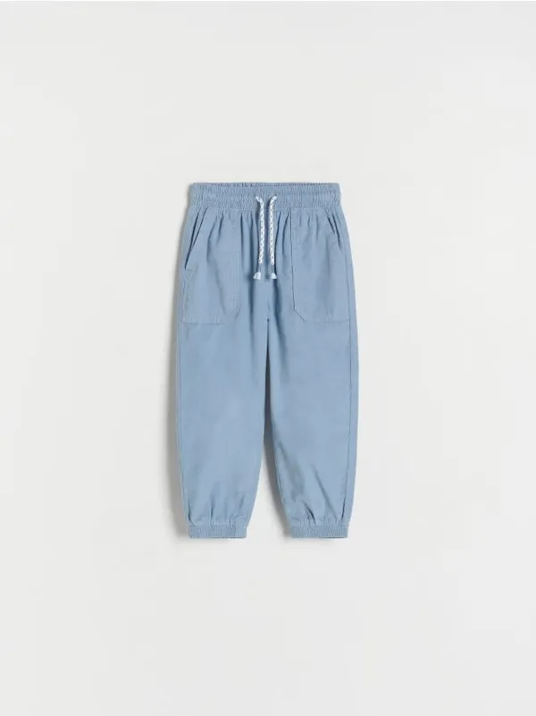Spodnie typu jogger, wykonane ze strukturalnej, bawełnianej tkaniny. - niebieski